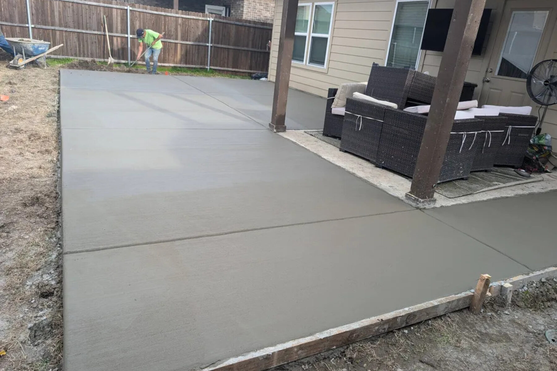 Finished backyard patio slab beside covered porch seating